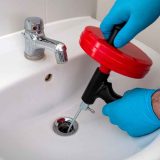 Using-a-drain-auger-also-known-as-a-plumbing-snake